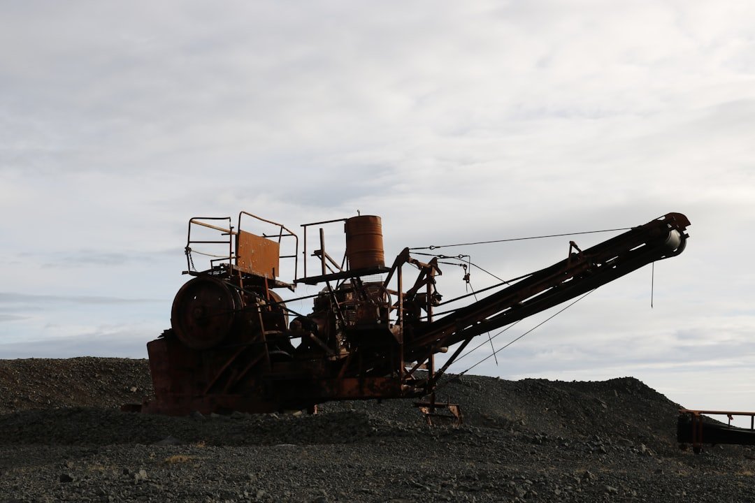 an old rusty machine sitting on top of a pile of dirt