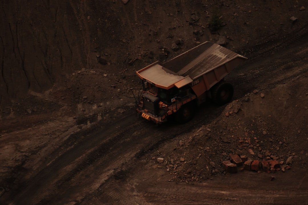 a dump truck driving down a dirt road