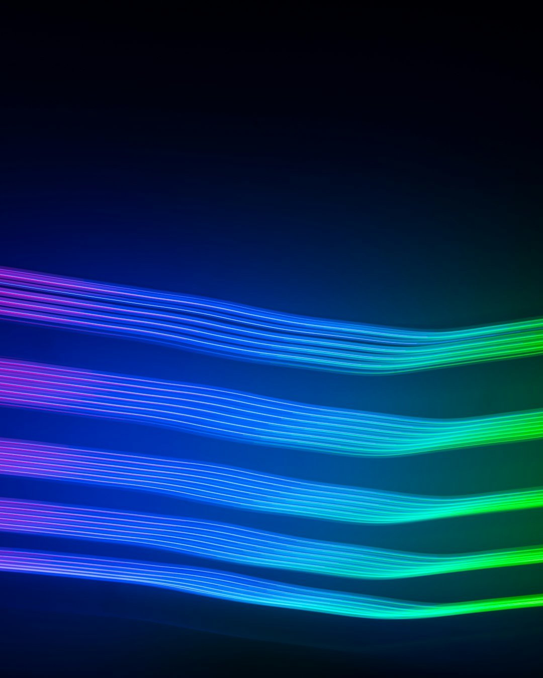 a black background with a multicolored wave of light