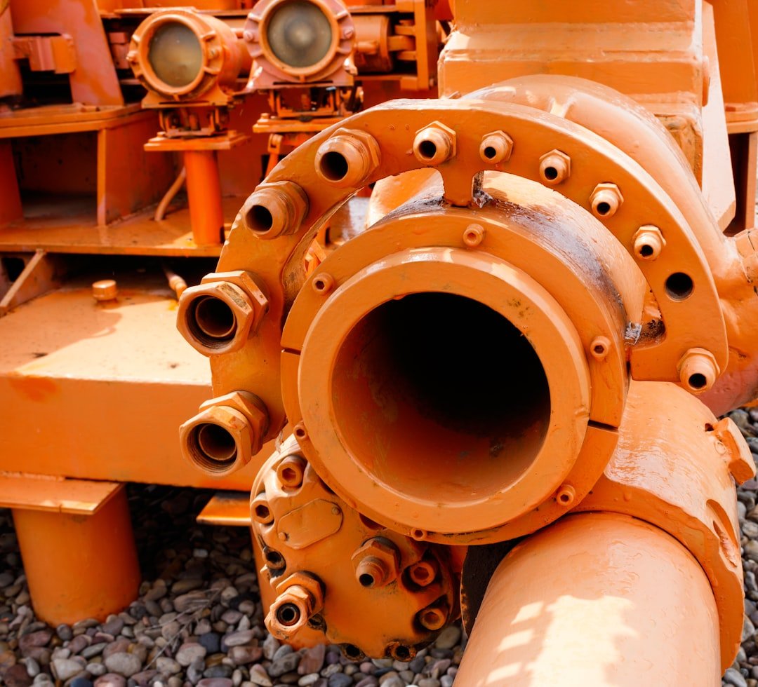 a large orange pipe laying on top of a pile of rocks