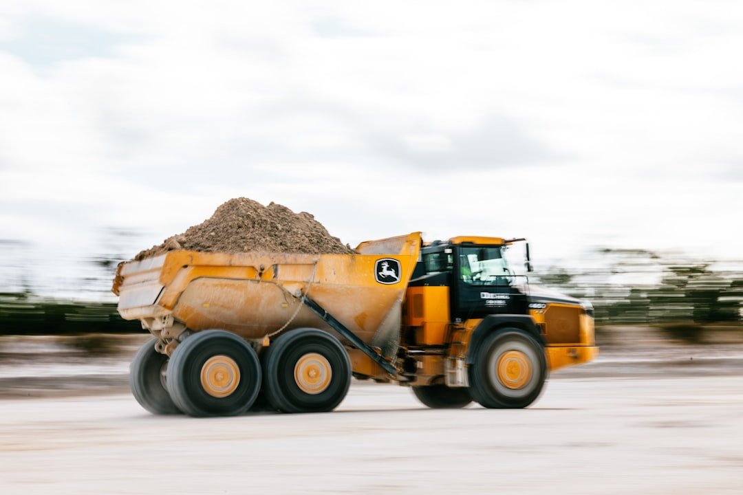 A yellow dump truck is hauling dirt.