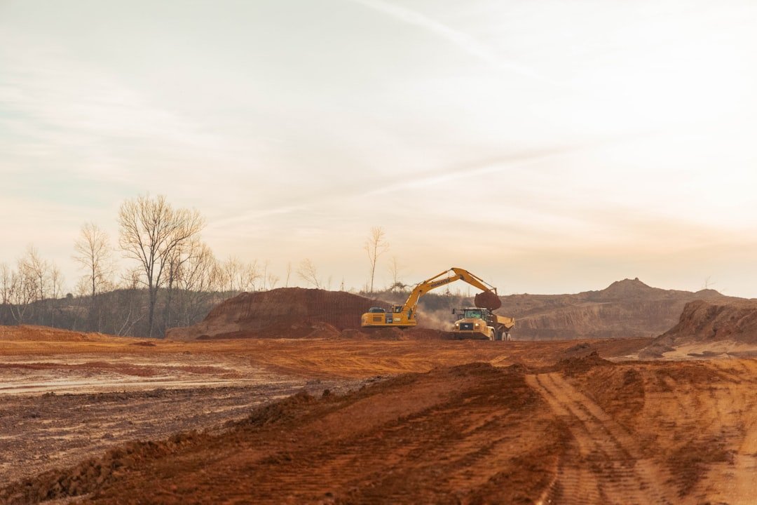 An excavator works on an earthy construction site.
