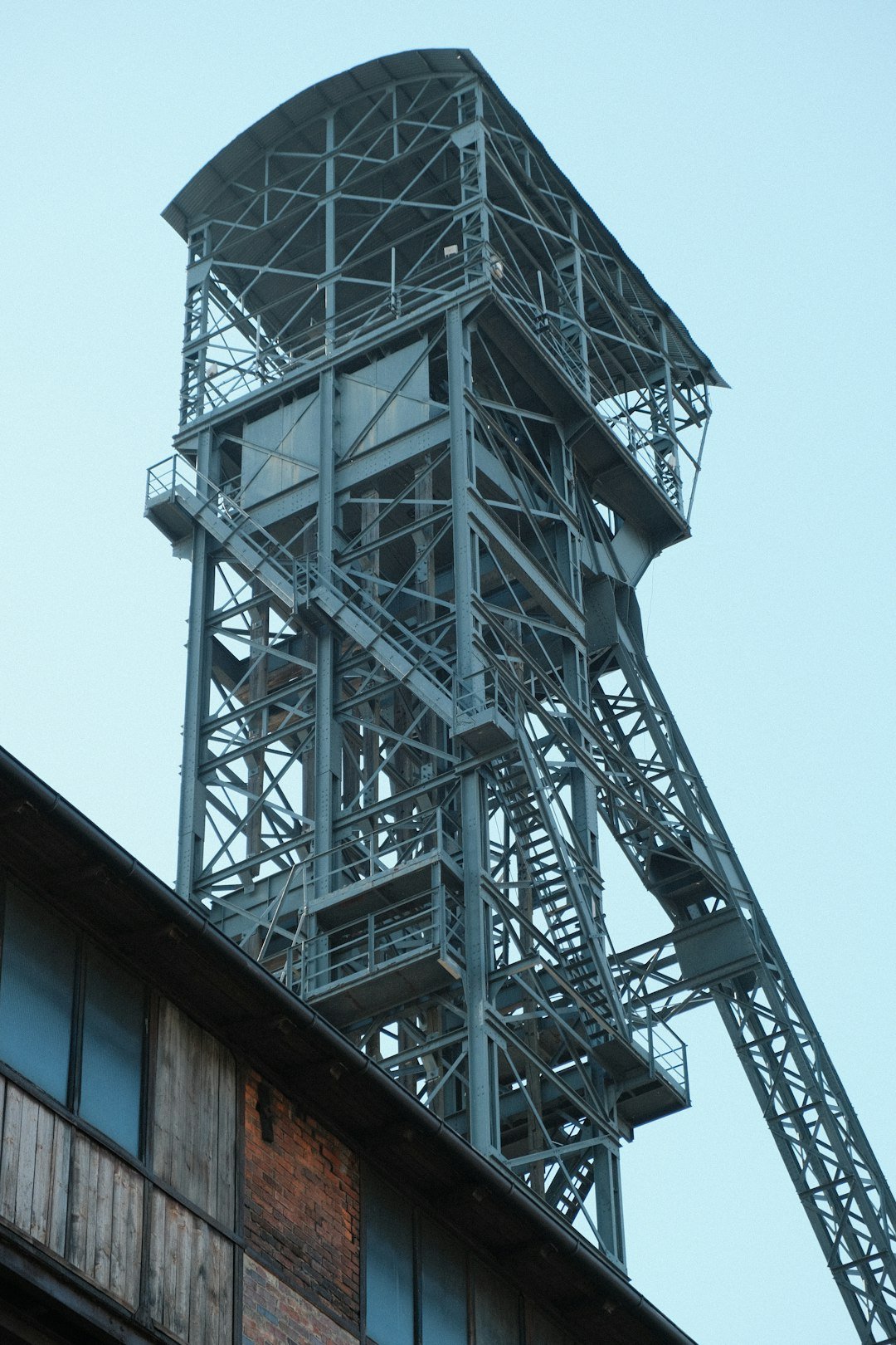 Industrial mine headframe structure against a pale sky