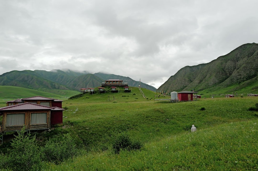 Green rolling hills with buildings and mountains