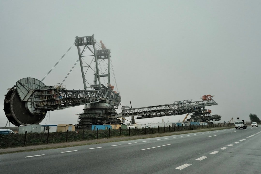 A large crane sitting on the side of a road