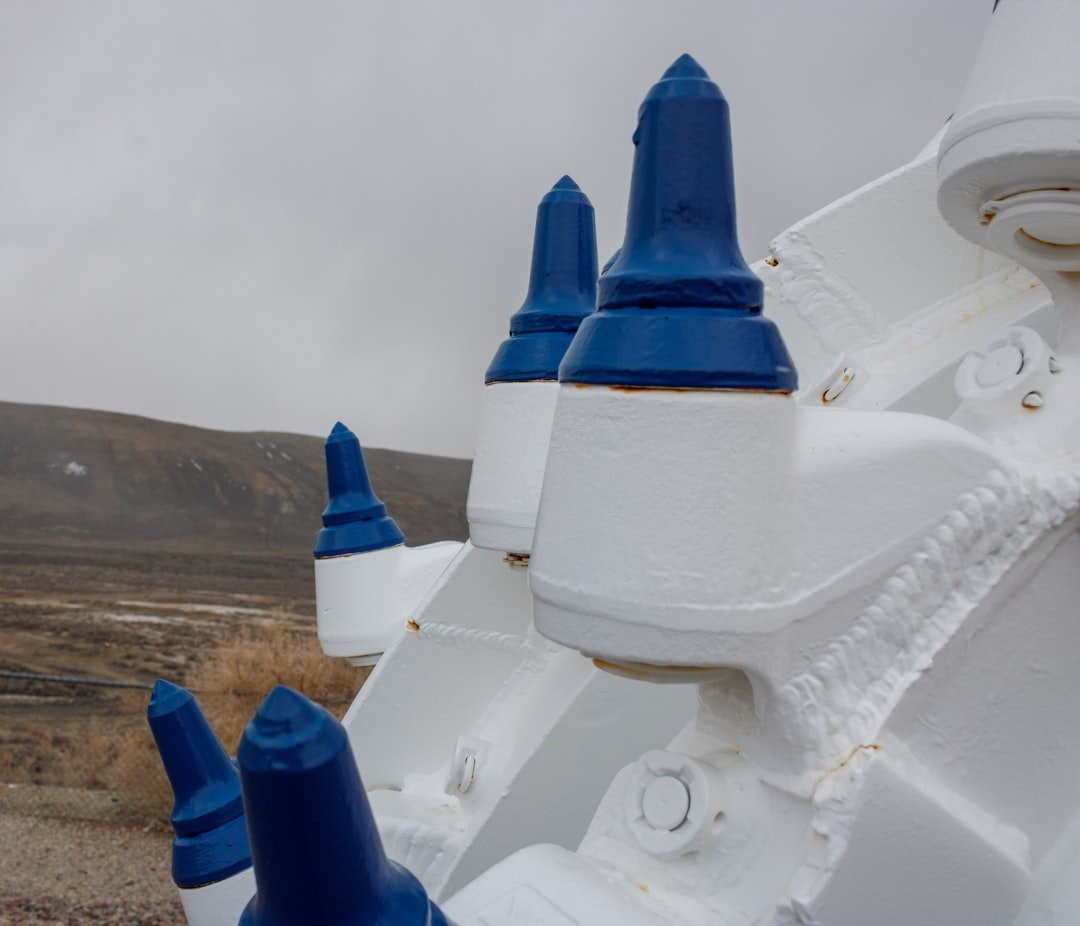 a close up of a blue and white object with a mountain in the background