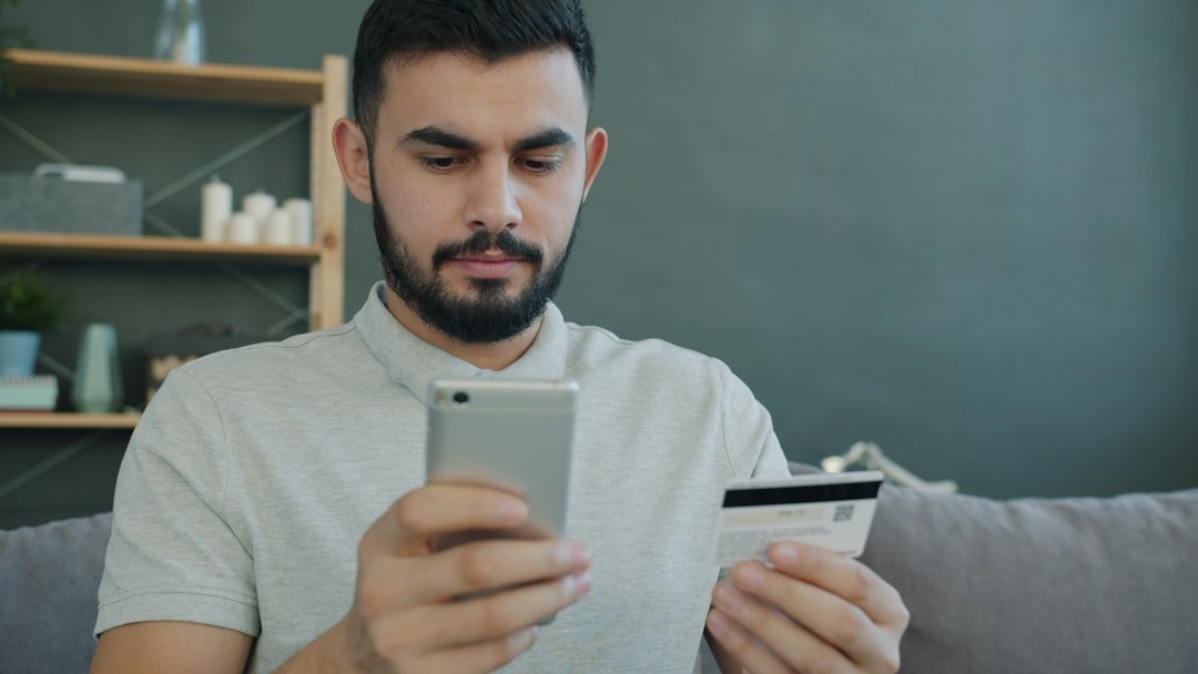 Man holding phone and credit card for online shopping