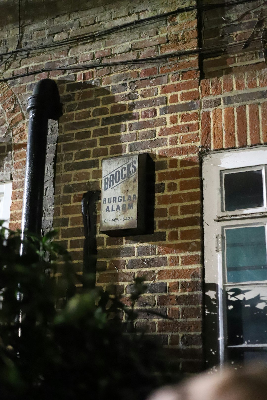 Old brocks burglar alarm box on brick wall
