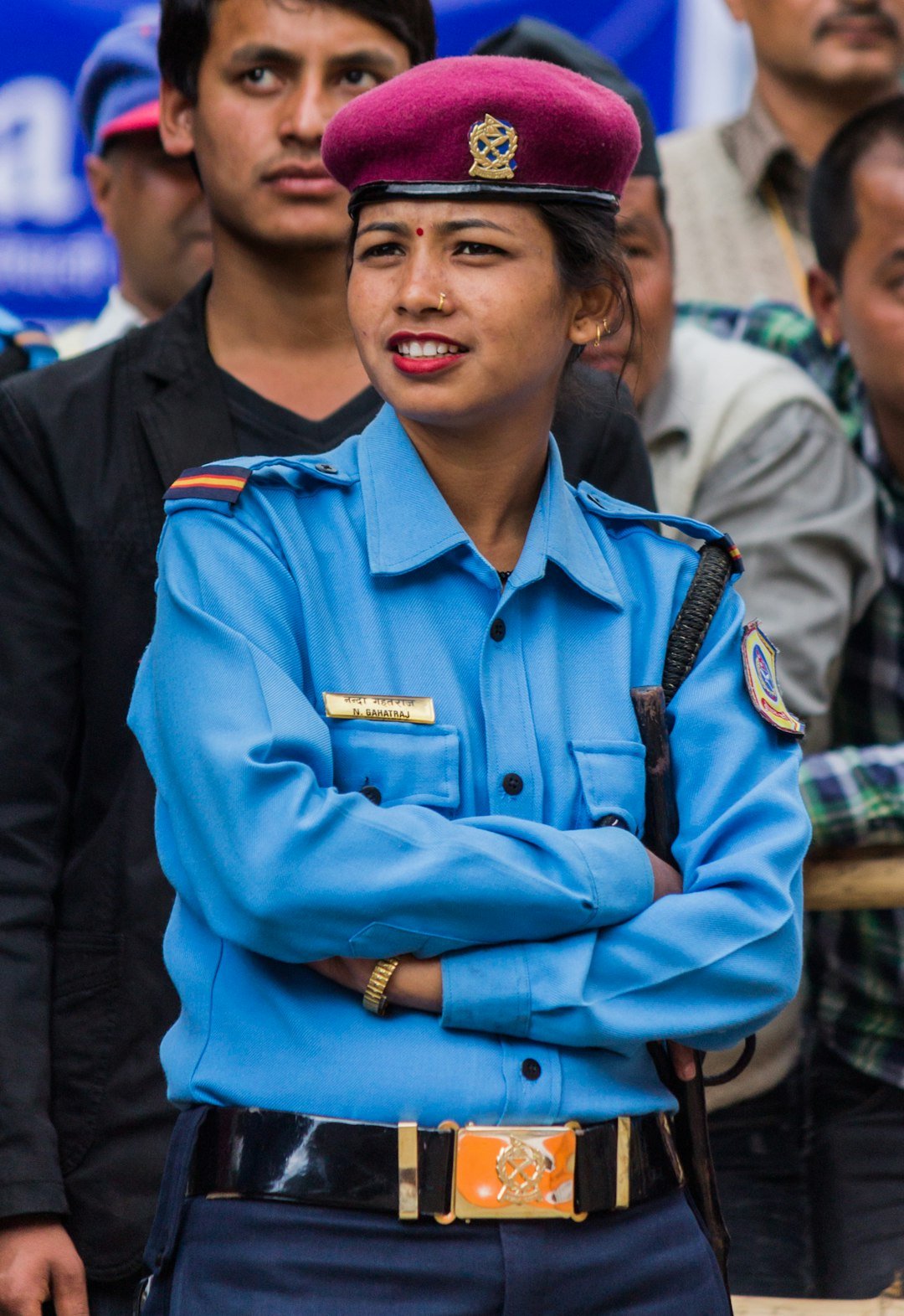 A female police officer in uniform with arms crossed