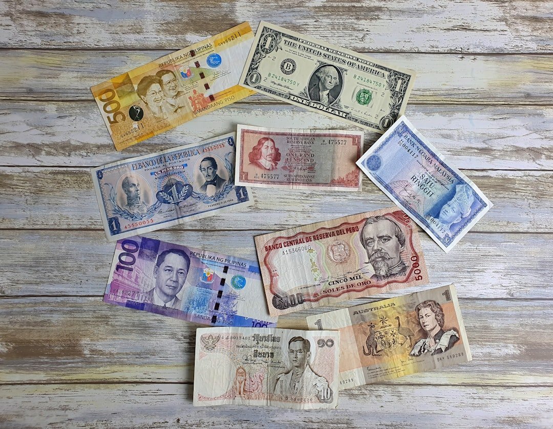 a bunch of different currency sitting on top of a wooden table