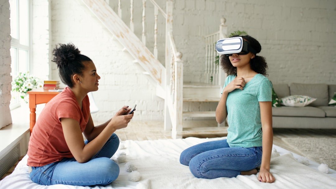 Two young women experiencing virtual reality together indoors.