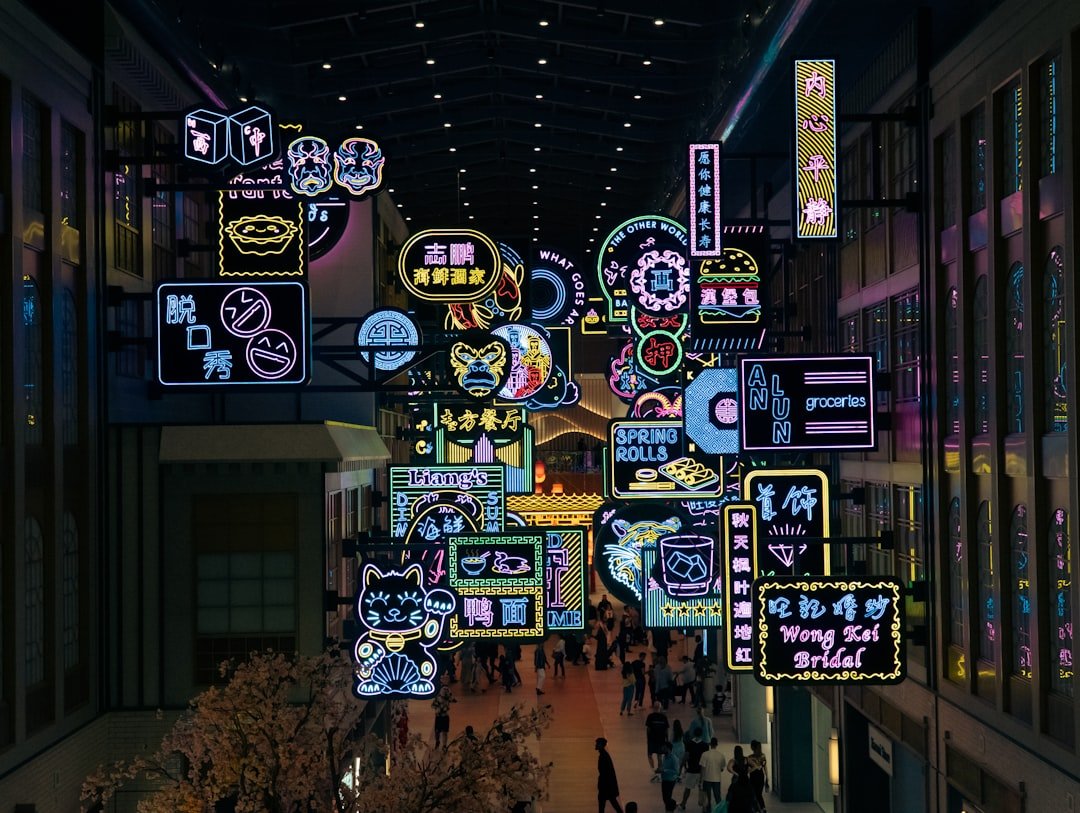 A group of people walking through a mall filled with neon signs